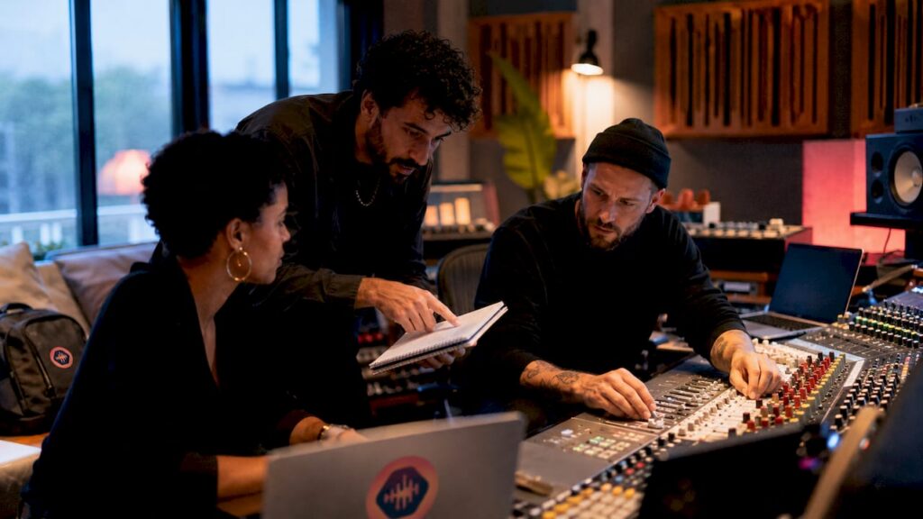 Hands adjusting mixing console in studio