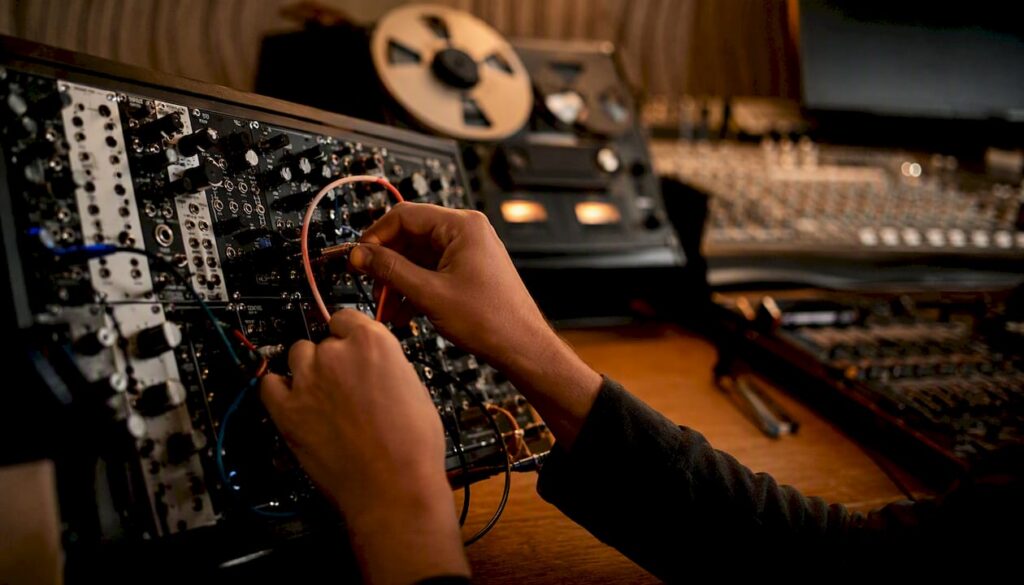 Hands connecting audio cables in sound studio
