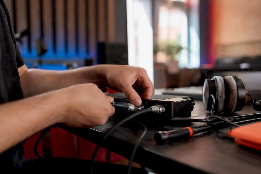Hands connecting audio cables in studio