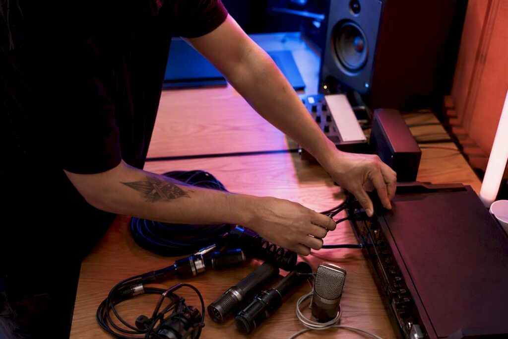 Hands preparing audio session cables in studio